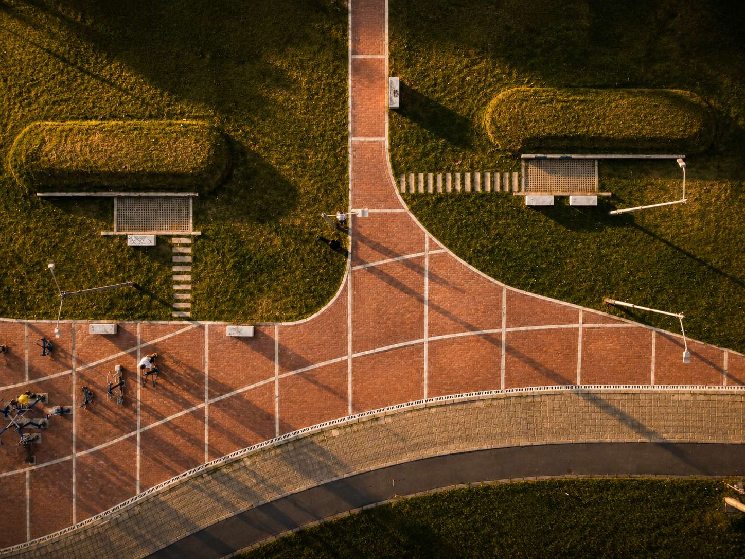 Permeable brick paving and pedestrian circulation improving accessibility and stormwater management in a public park.